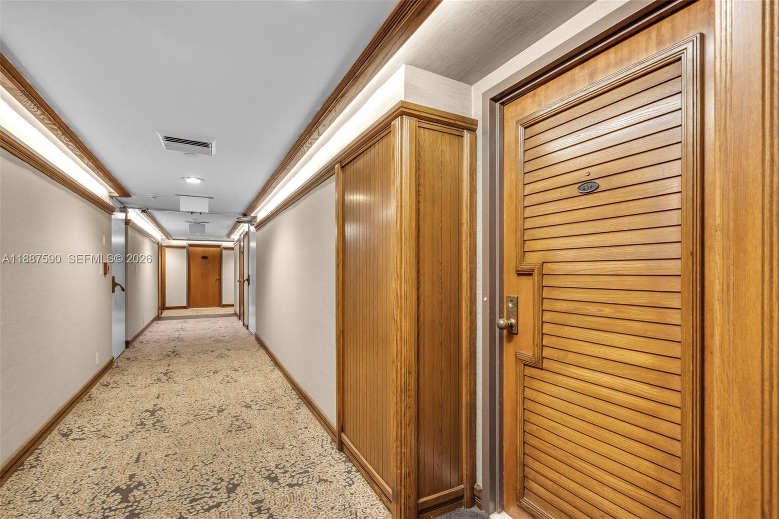 A carpeted hallway features wood-paneled doors, recessed lighting, and a built-in wooden cabinet — 1000 Quayside Ter # 505, Miami FL 33138, MIAMI, FL