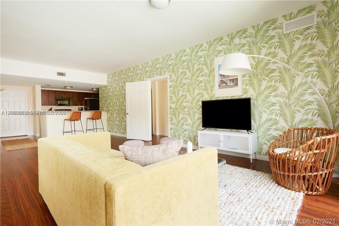 A living room features palm-leaf wallpaper, a yellow sofa, and a glass-topped coffee table — 568 NE 66th St # 501, Miami FL 33138, MIAMI, FL