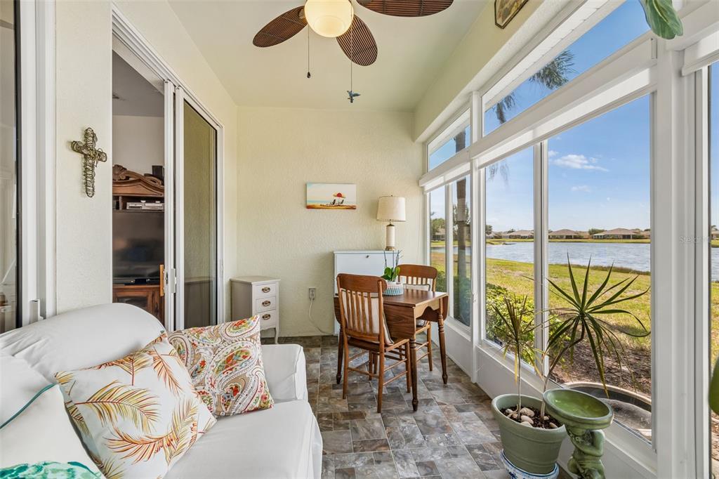 A sunroom with tile flooring, a dining set, and large windows overlooking a lake — 2011 SIFIELD GREENS WAY UNIT 71, SUN CITY CENTER, FL