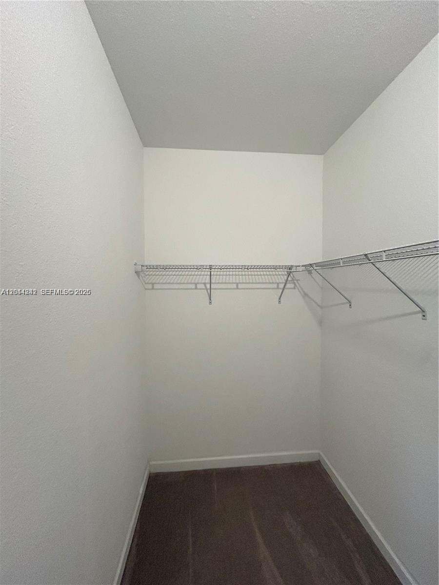A walk-in closet features white walls, gray carpeting, and white wire shelving — 22913 SW 99th Ave, Cutler Bay FL 33190, CUTLER BAY, FL