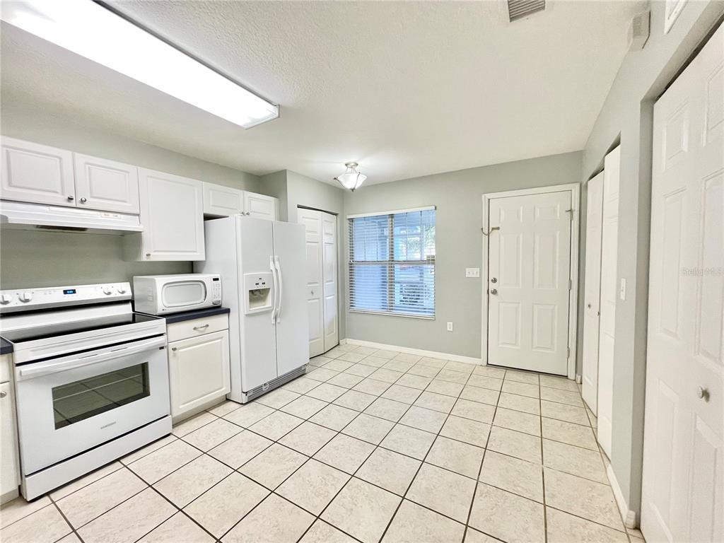 A kitchen with white cabinets, white appliances, and light-colored tile flooring — 2348 SW 42ND DRIVE UNIT 151, GAINESVILLE, FL