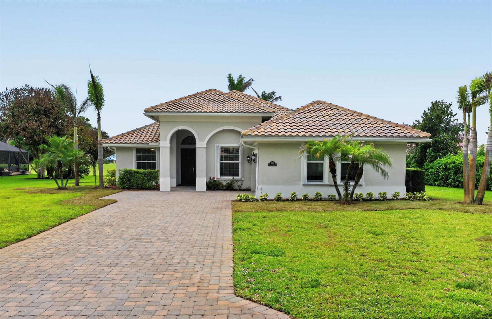 A single-story house with a tiled roof, arched entryway, and a paved driveway — 9531 Shadow Lane, Fort Pierce FL 34951, FORT PIERCE, FL