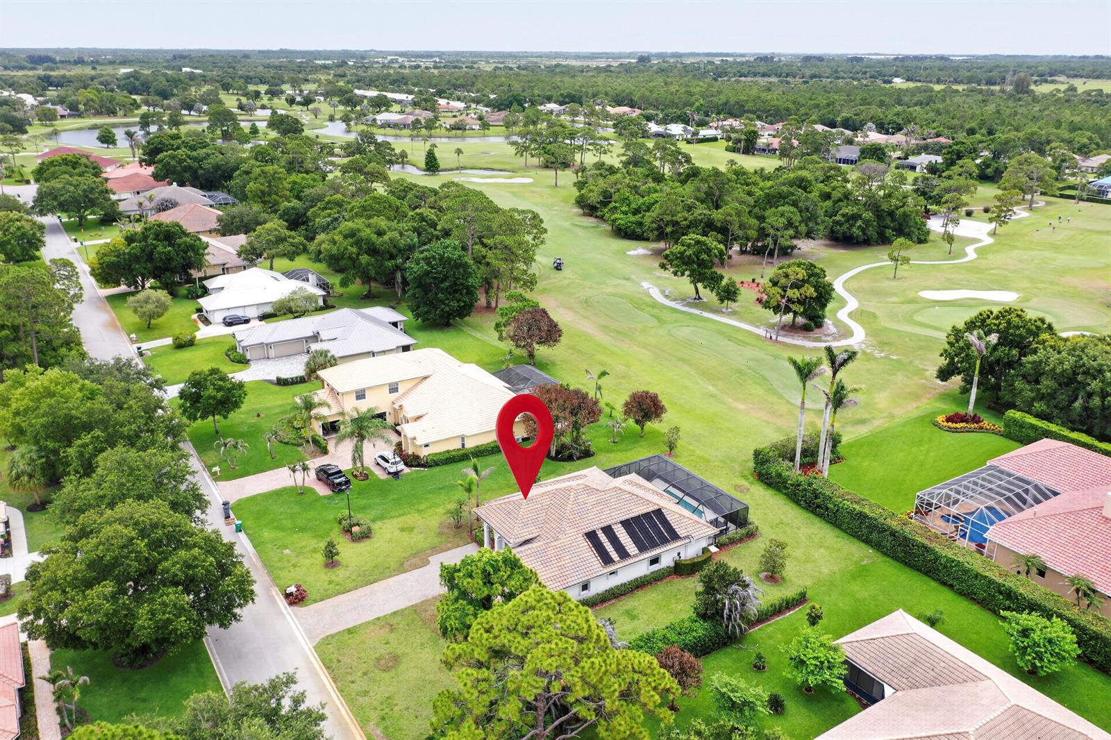 An aerial view shows a residential house with solar panels on a golf course lot — 9531 Shadow Lane, Fort Pierce FL 34951, FORT PIERCE, FL
