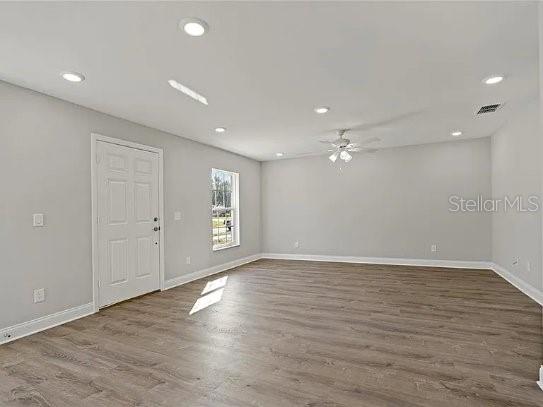 A spacious room with light gray walls, recessed lighting, a ceiling fan, and wood-look flooring — 800 WARE AVENUE NE, WINTER HAVEN, FL