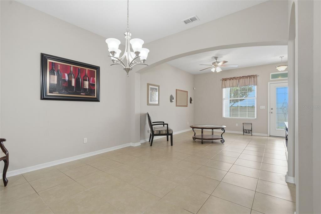 A dining area with tile flooring, a chandelier, and an arched opening to a living space — 556 JUNIPER SPRINGS DRIVE, GROVELAND, FL