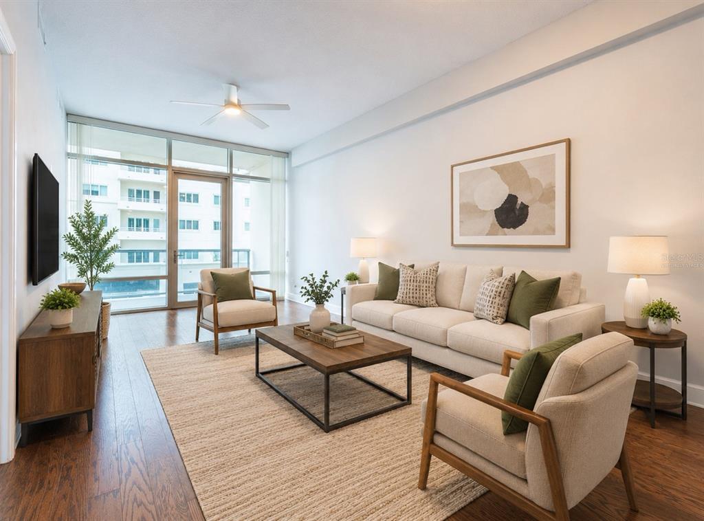 A modern living room features a beige sofa, two armchairs, a coffee table, and balcony access — 101 S EOLA DRIVE UNIT 614, ORLANDO, FL