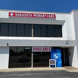 The exterior of a two-story commercial building features a Sarasota Primary Care sign and available space — 3131 CLARK ROAD UNIT 101, SARASOTA, FL