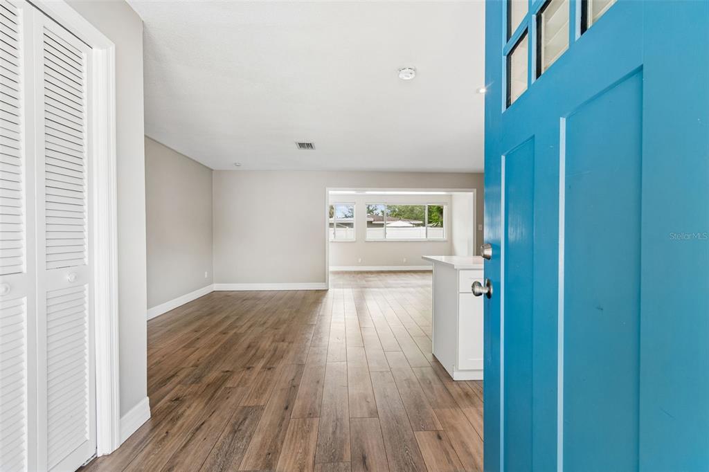 A modern kitchen features white cabinets, quartz countertops, stainless steel appliances, and a large window — 1943 BARBARA AVENUE, CLEARWATER, FL