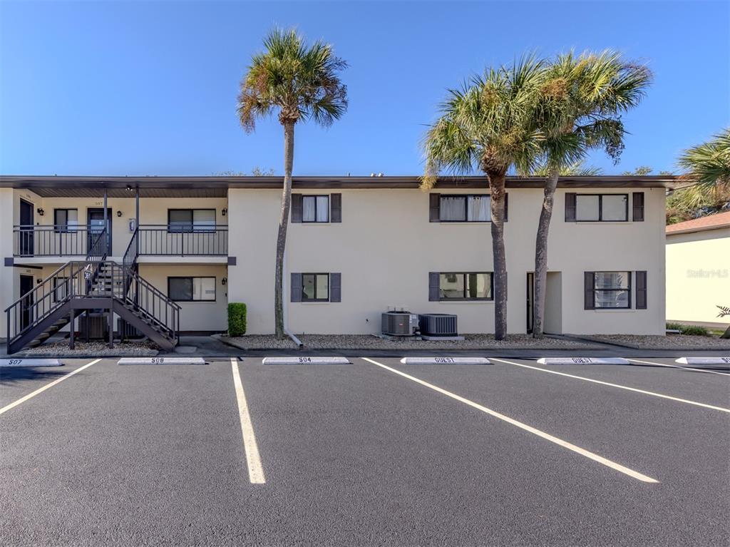A two-story apartment building with a parking lot in front and two palm trees — 361 AIRPORT AVENUE E UNIT 508, VENICE, FL
