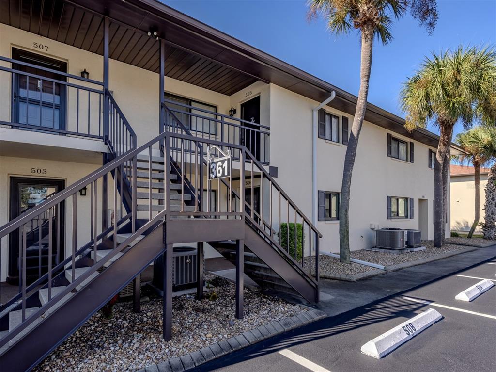 An exterior view of a two-story apartment building with metal staircases and numbered unit doors — 361 AIRPORT AVENUE E UNIT 508, VENICE, FL