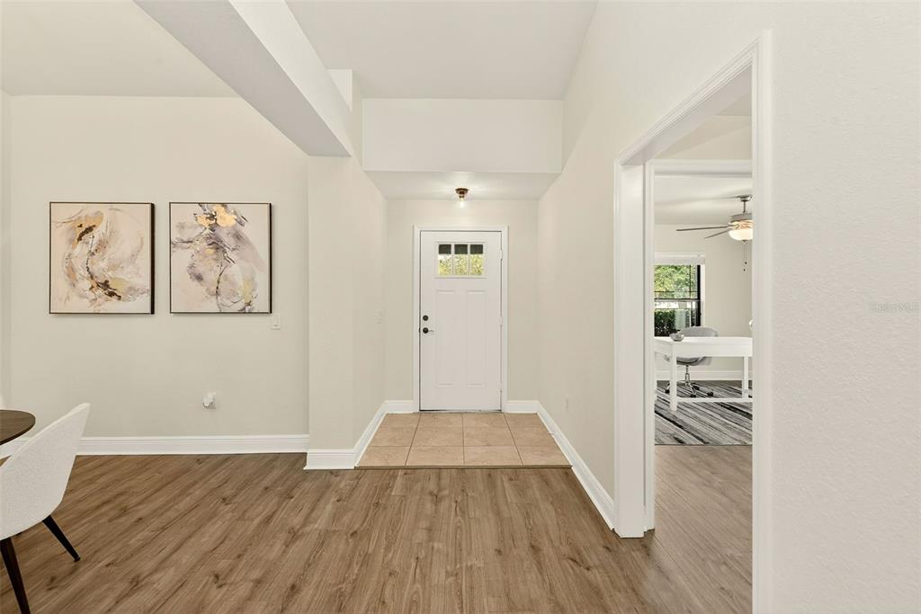 An entryway with tile flooring leads to a white front door and an adjacent room — 12220 LEGACY BRIGHT STREET, RIVERVIEW, FL