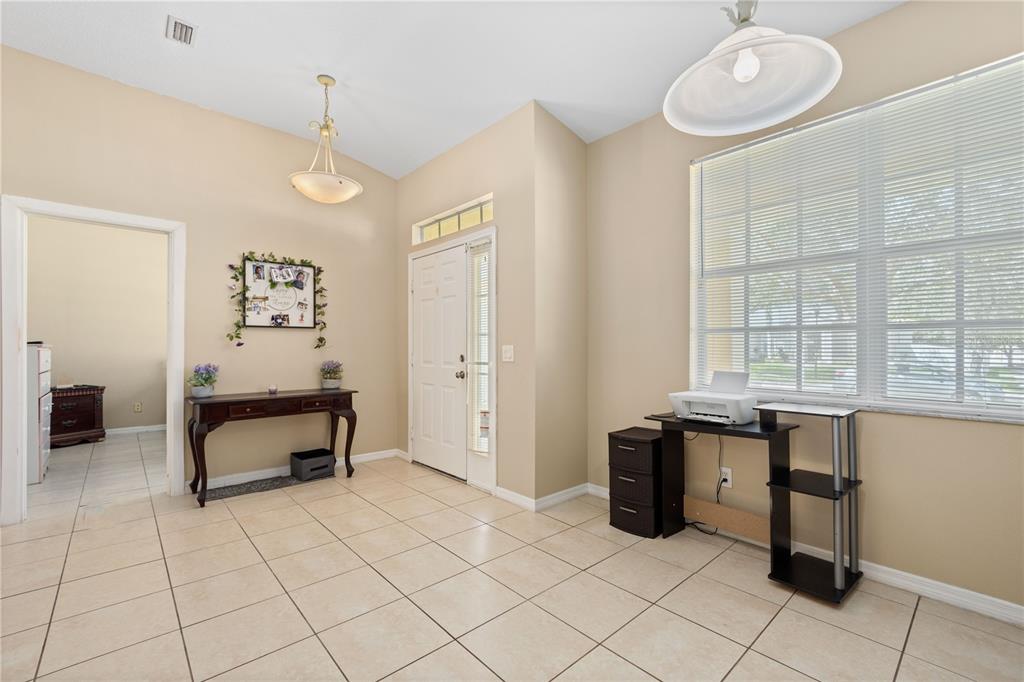 A tiled entryway features a console table, a desk with a printer, and a front door — 11328 BRIDGE PINE DRIVE, RIVERVIEW, FL
