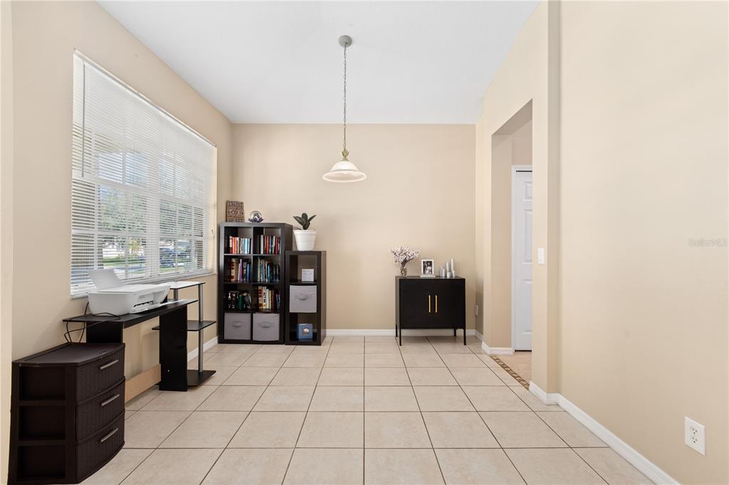 A room with beige walls, tile flooring, a window with blinds, and various storage furniture — 11328 BRIDGE PINE DRIVE, RIVERVIEW, FL