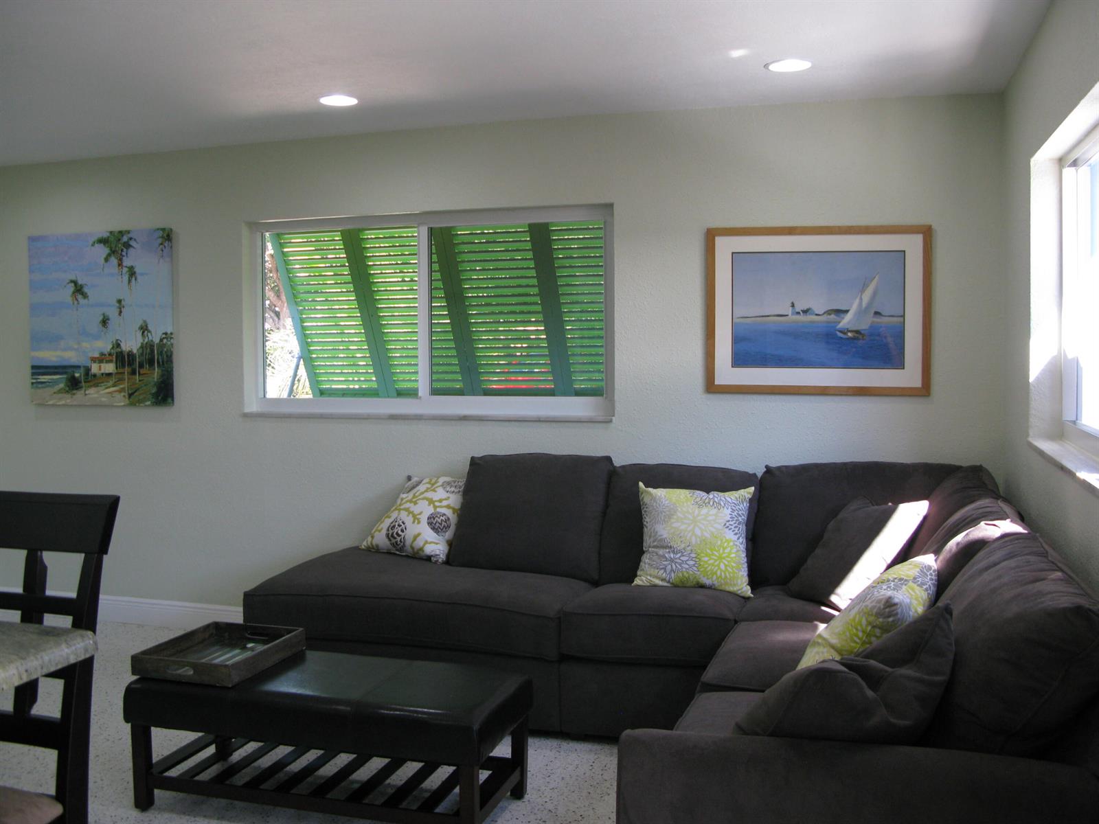 A living room features a dark sectional sofa, a coffee table, and two framed wall pictures — 13767 Oleander Avenue E, Juno Beach FL 33408, JUNO BEACH, FL