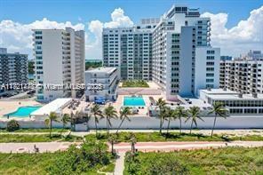 An aerial view shows multiple high-rise apartment buildings with swimming pools and surrounding coastal vegetation — 5401 Collins Ave # 430, Miami Beach FL 33140, MIAMI BEACH, FL
