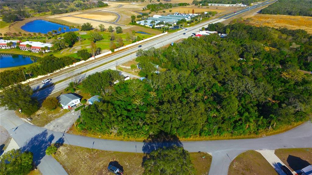 An aerial view shows a wooded lot bordered by a road and a highway — 0 POINSETTIA DRIVE, LAKE WALES, FL