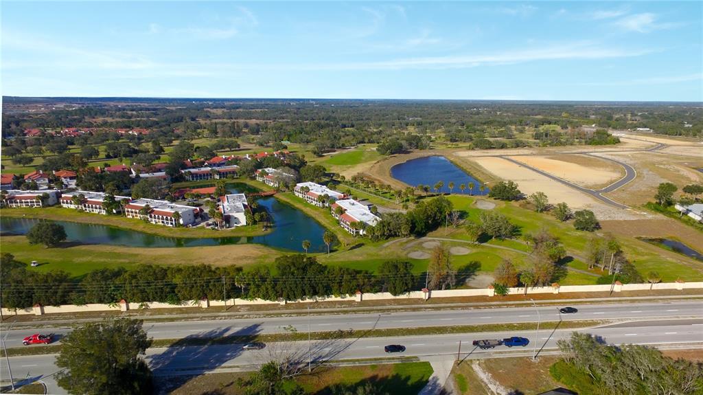 An aerial view shows a multi-building residential complex situated beside a lake and golf course — 0 POINSETTIA DRIVE, LAKE WALES, FL