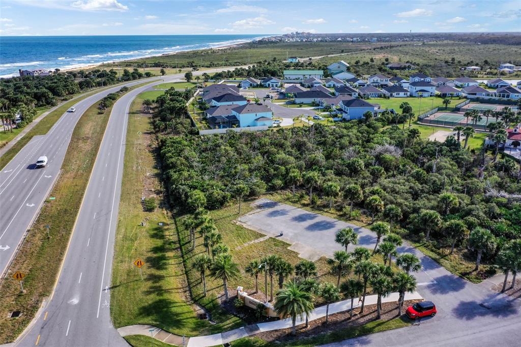 An aerial view shows a vacant lot with a paved area next to a coastal highway — 6700 N OCEAN SHORE BOULEVARD, PALM COAST, FL