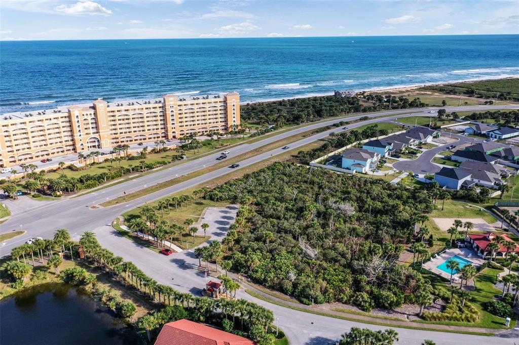 An aerial view shows a coastal landscape with a large resort, road, and residential neighborhood — 6700 N OCEAN SHORE BOULEVARD, PALM COAST, FL