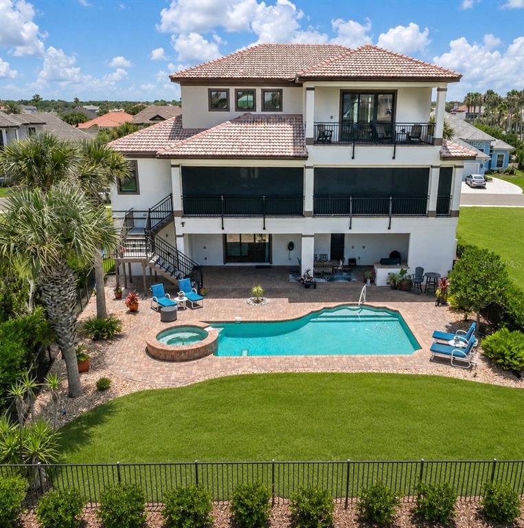 An aerial view of a multi-story house with a pool, spa, and screened-in balcony — 7 HAMMOCK BEACH CIRCLE S, PALM COAST, FL