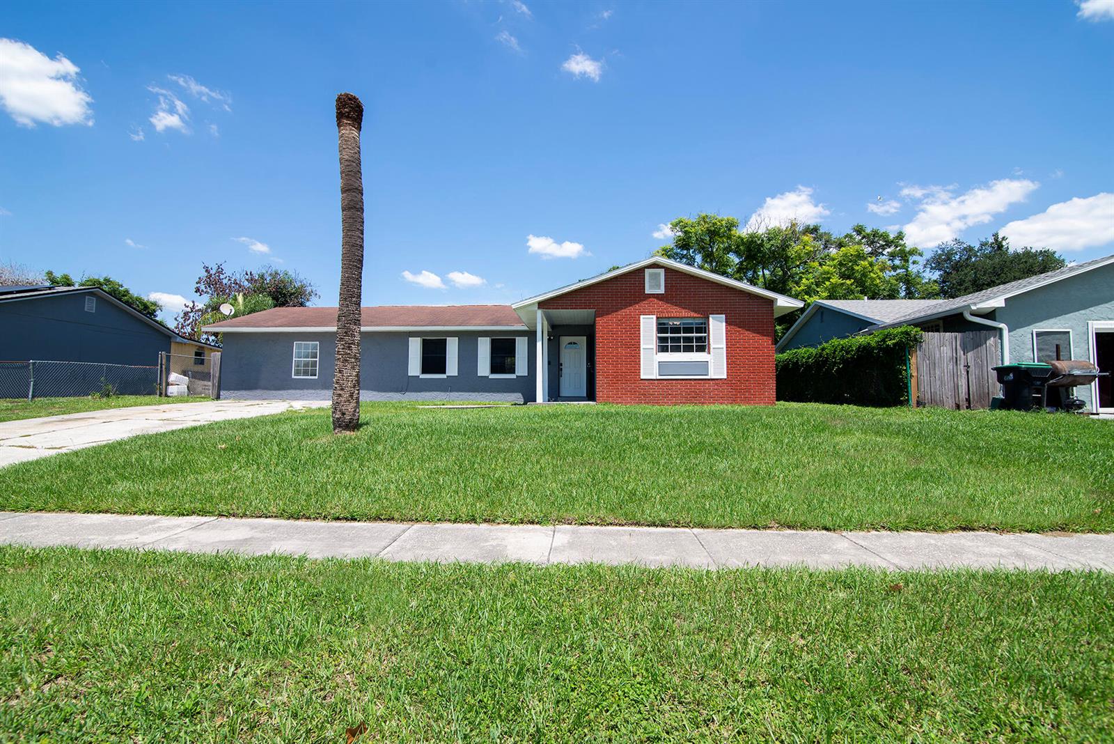 A single-story house features a red brick front section, gray siding, and a front lawn — 2137 San Jose Boulevard, Orlando FL 32808, ORLANDO, FL