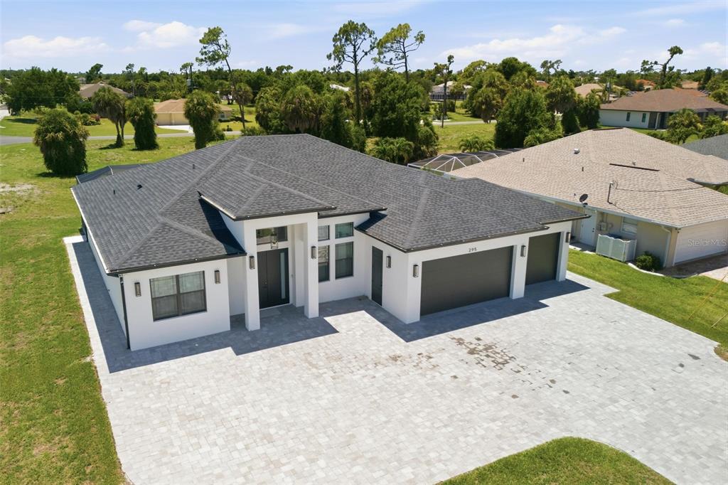 An aerial view of a modern white house with a dark roof and paved driveway — 295 WHITE MARSH LANE, ROTONDA WEST, FL