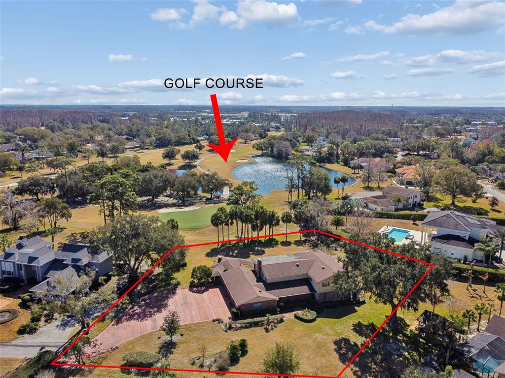 An aerial view shows a house with a red-outlined yard overlooking a golf course — 29244 WHIPPORWILL LANE, WESLEY CHAPEL, FL
