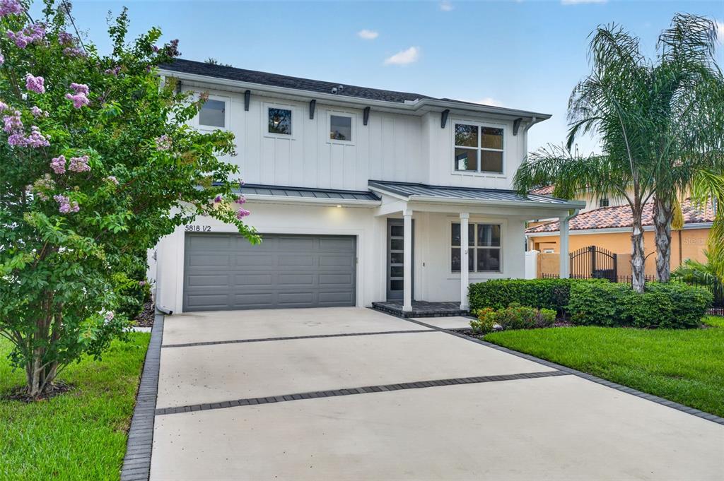 A two-story white house with a gray garage door and a paved driveway — 5818 1/2 S 6TH STREET, TAMPA, FL