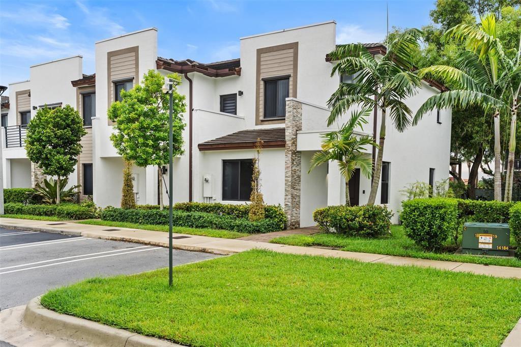 A two-story white townhouse with a flat roof, stone accents, and a small front lawn — 340 NE 208th Terrace # 340, Miami FL 33179, MIAMI, FL