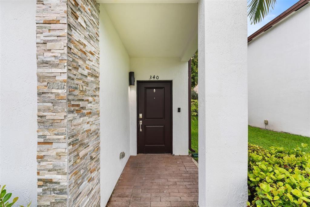A dark brown front door with the number 340 sits under a covered entryway — 340 NE 208th Terrace # 340, Miami FL 33179, MIAMI, FL