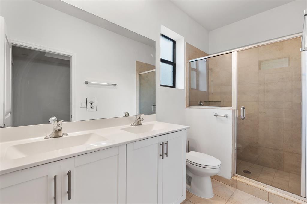 A bathroom features a double vanity with white cabinets, a mirror, and a glass shower — 340 NE 208th Terrace # 340, Miami FL 33179, MIAMI, FL