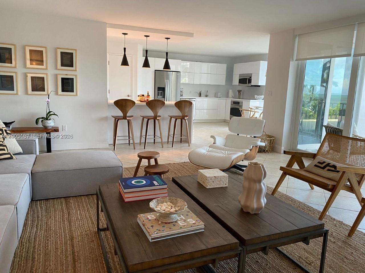 A living room with a sectional sofa, coffee tables, and an open kitchen with bar stools — 881 Ocean Dr # 3E, Key Biscayne FL 33149, KEY BISCAYNE, FL