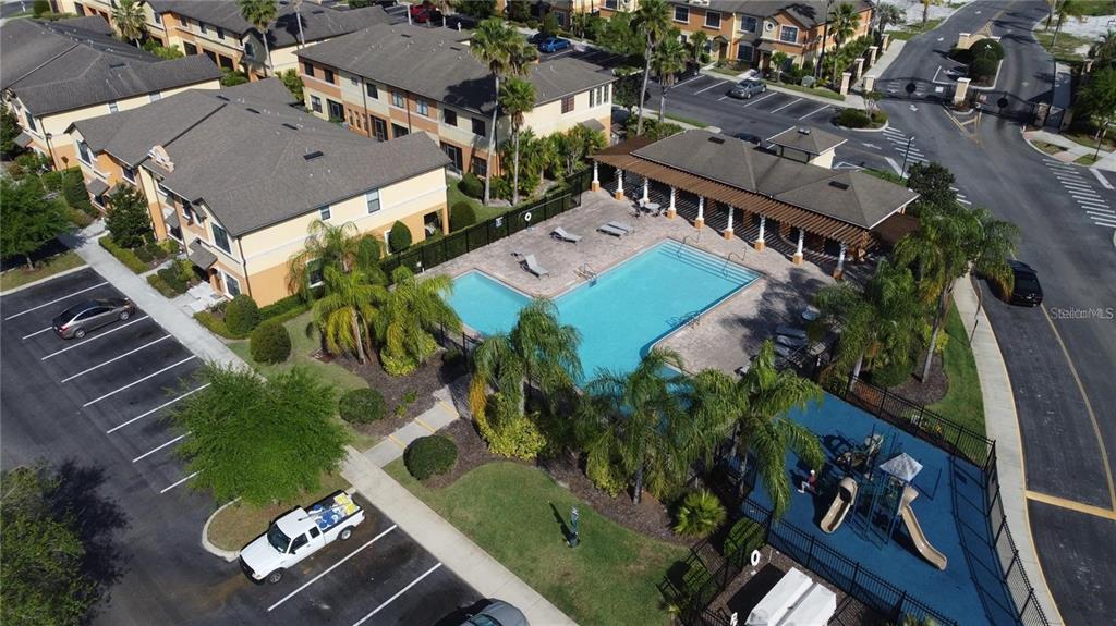An aerial view shows a swimming pool, playground, and parking lot near residential apartment buildings — 4210 WINDSOR LAKE CIRCLE, SANFORD, FL