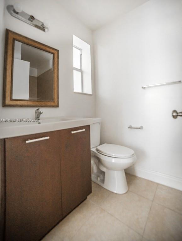 A bathroom features a dark wood vanity, a rectangular mirror, and a white toilet — 500 SW 9th Ave # 1, Miami FL 33130, MIAMI, FL