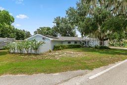A light blue exterior wall features a front door, a window, and a decorative metal wheel — 1901 N LAKE ELOISE DRIVE, WINTER HAVEN, FL