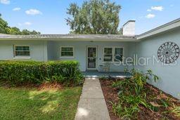 A light blue single-story house features a concrete walkway leading to the front entrance — 1901 N LAKE ELOISE DRIVE, WINTER HAVEN, FL