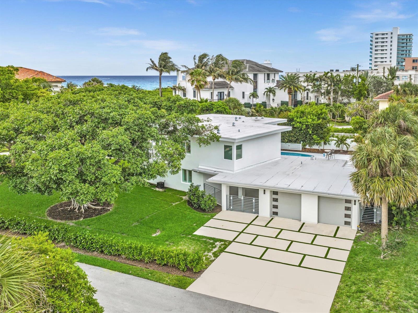 An aerial view of a white two-story house with a flat roof and paved driveway — 1903 Bay Drive, Pompano Beach FL 33062, POMPANO BEACH, FL