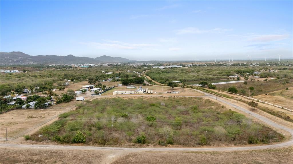 An aerial view shows a large, undeveloped plot of land surrounded by rural landscape — OBDULIA, SANTA ISABEL, PR