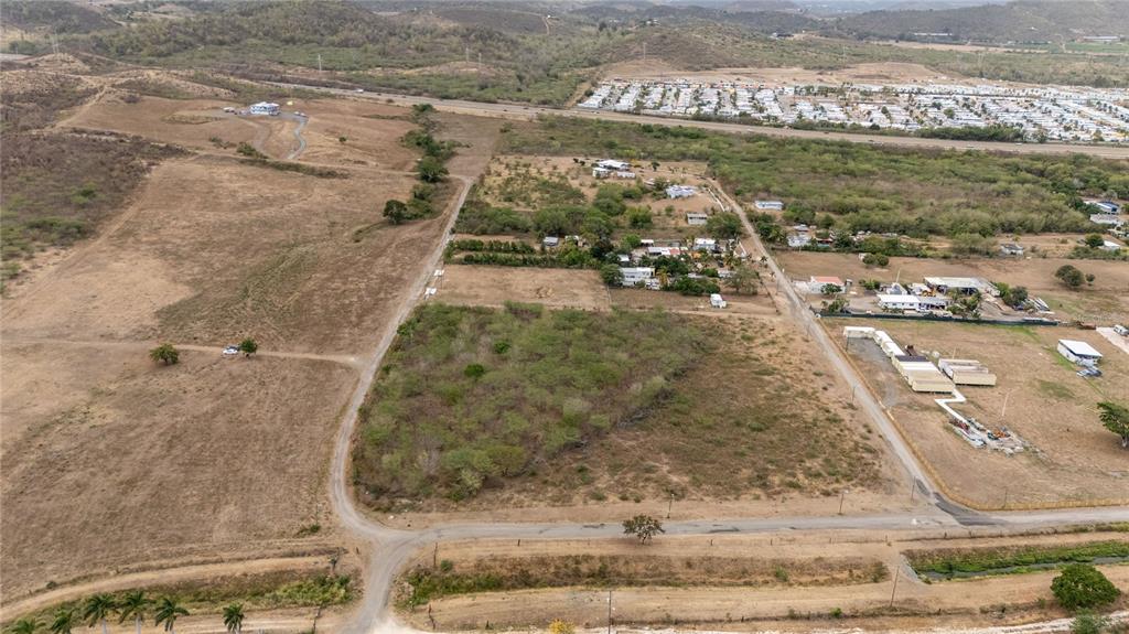 An aerial view shows a large, undeveloped plot of land surrounded by rural terrain — OBDULIA, SANTA ISABEL, PR