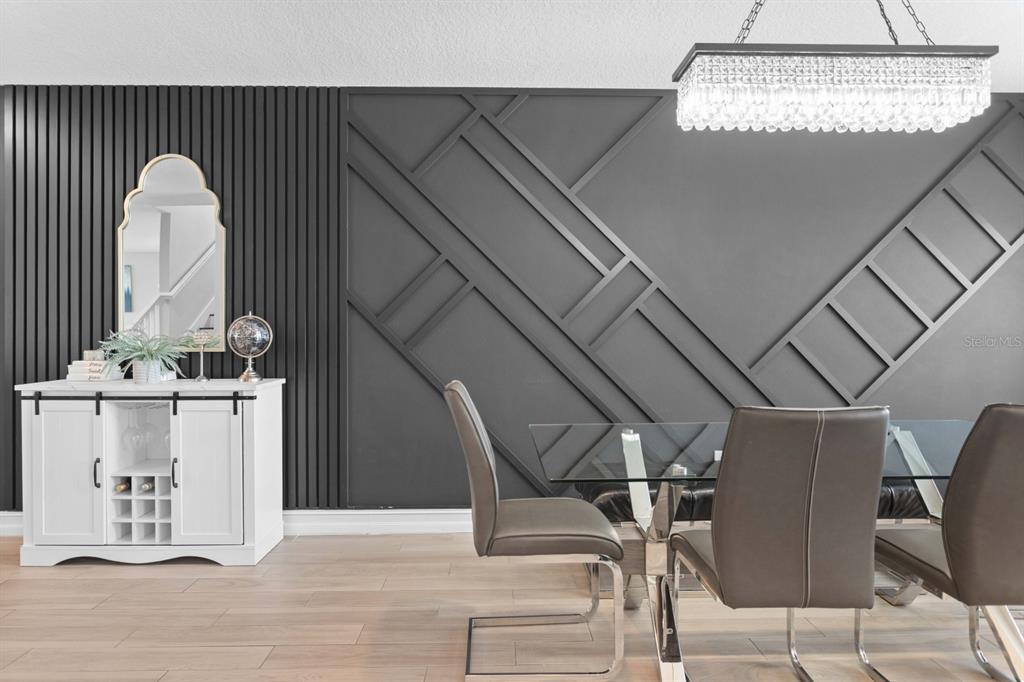 A dining room features a dark accent wall with geometric molding and vertical slat paneling — 5351 BRIDGE STREET UNIT 42, TAMPA, FL