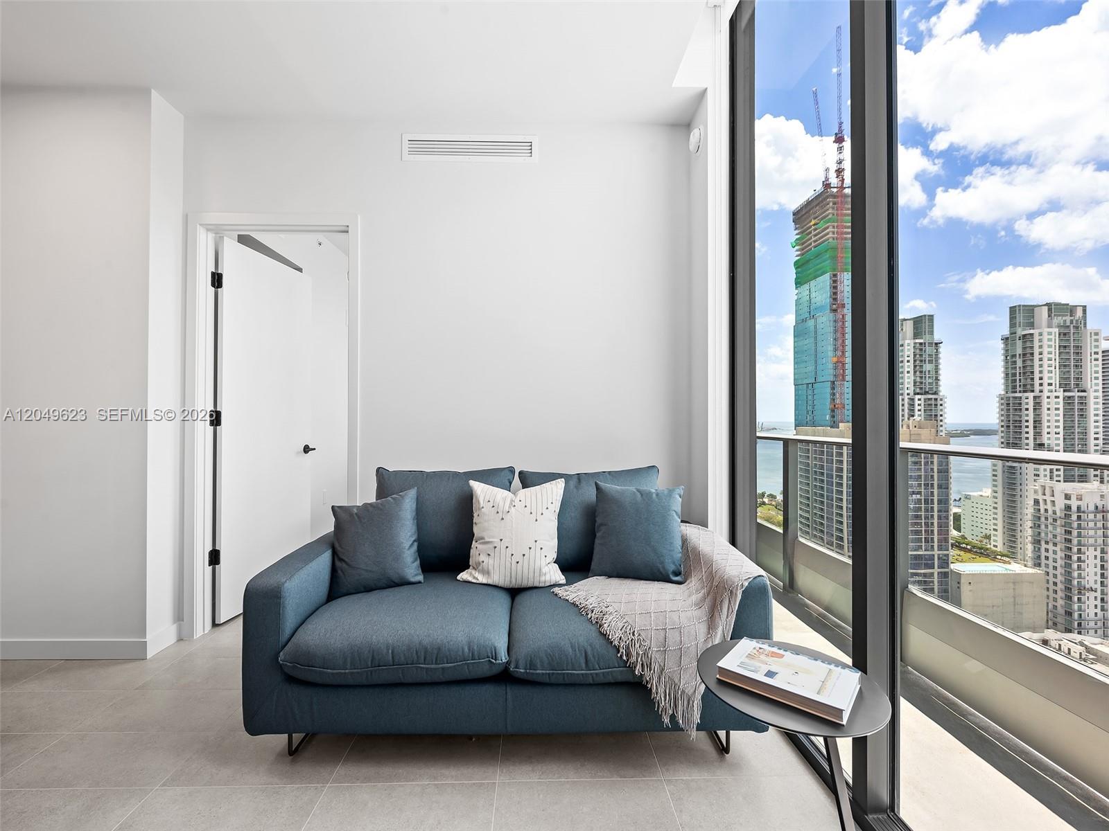 A modern kitchen features light wood cabinets, a black faucet, and a small dining table — 121 NE 5th St # 3703, Miami FL 33132, MIAMI, FL