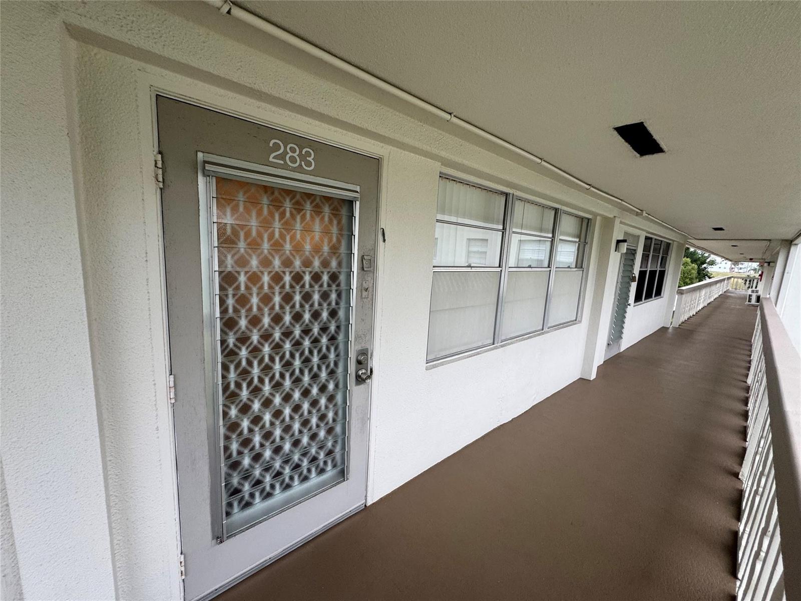 An exterior walkway features a gray door numbered 283 with a decorative metal screen — 283 Ventnor # 283, Deerfield Beach FL 33442, DEERFIELD BEACH, FL