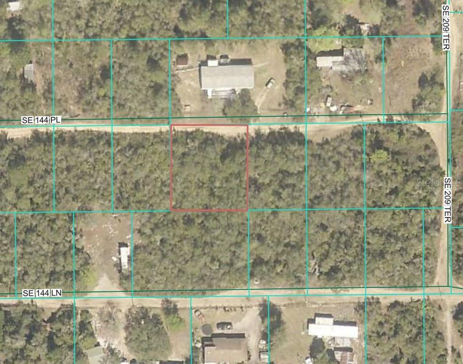 This aerial map shows a rectangular, wooded vacant lot outlined in red — SE 144TH PLACE LOTS 28 29 30 31, UMATILLA, FL