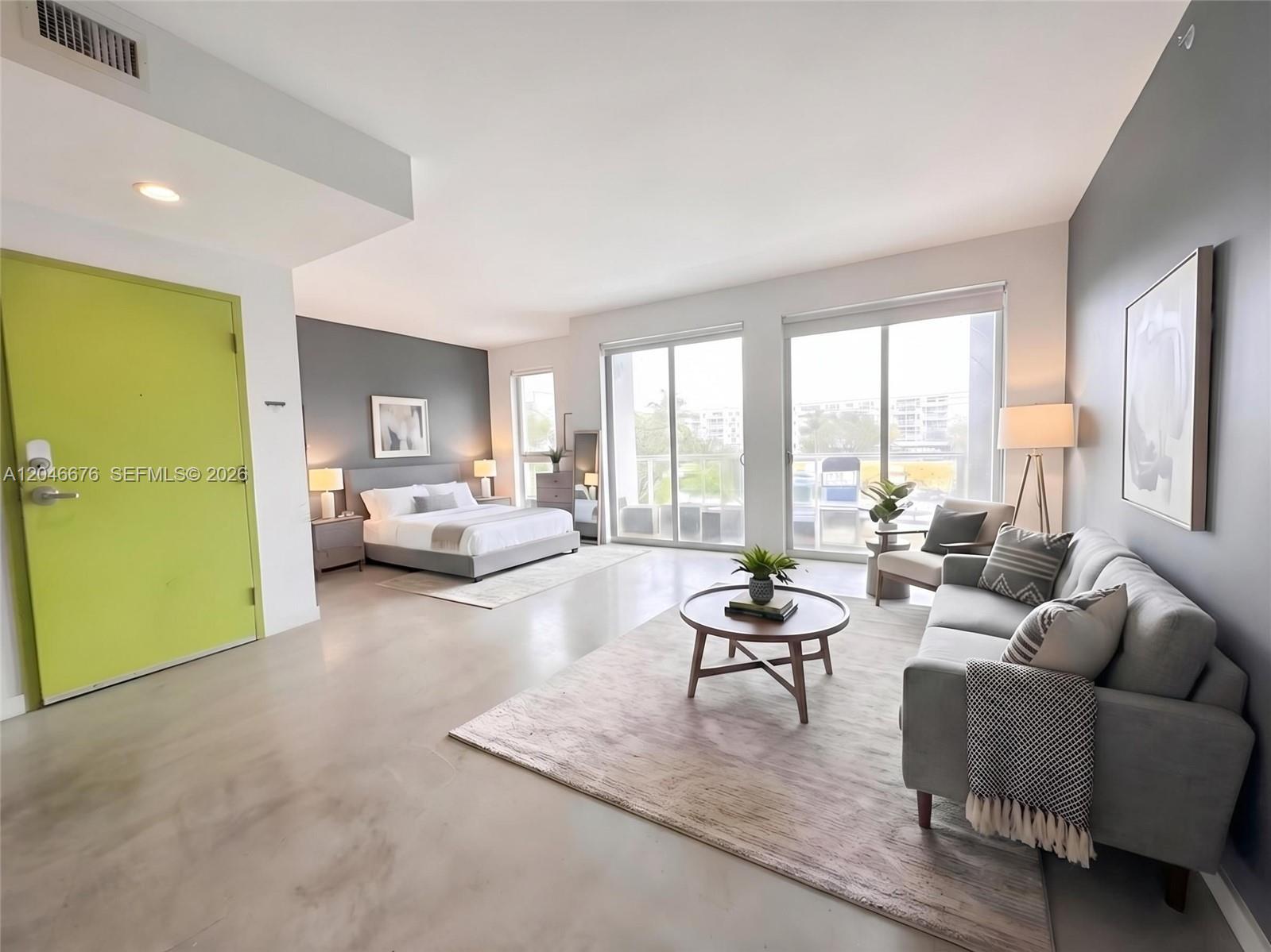 This studio apartment features a lime green door, gray accent walls, and concrete flooring — 769 NW 1st St # 301, Miami FL 33128, MIAMI, FL