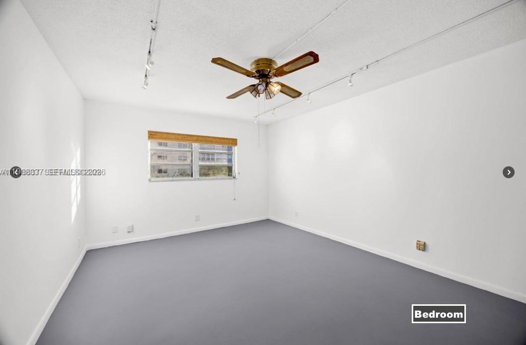 An empty bedroom features white walls, gray carpeting, a ceiling fan, and a single window — 619 NE 14th Ave # 304, Hallandale Beach FL 33009, HALLANDALE BEACH, FL