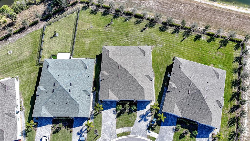 An aerial view shows three suburban houses with gray roofs and paved driveways — 1988 W PALMS DRIVE, PORT CHARLOTTE, FL