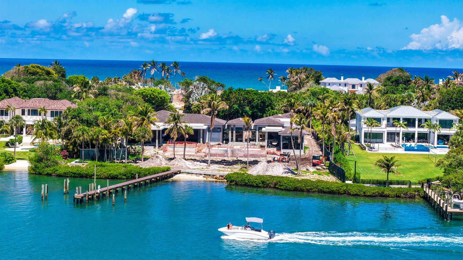 An aerial view shows a waterfront property under construction with a boat passing by — 508 S Beach Road, Jupiter Island FL 33455, JUPITER ISLAND, FL