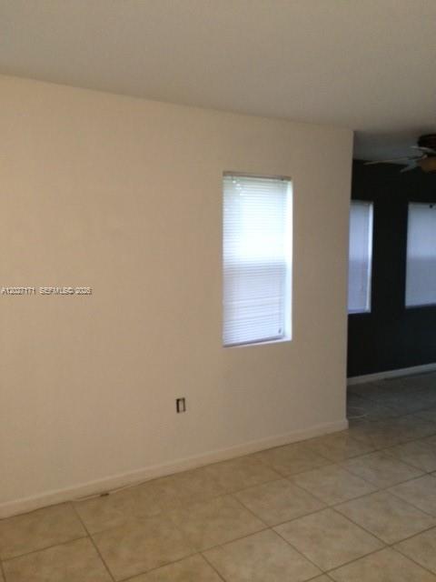 A room with beige tile flooring, a single window with blinds, and a dark accent wall — 1702 N 28th Ave # 1, Hollywood FL 33020, HOLLYWOOD, FL
