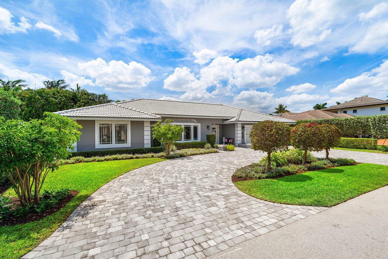A gray single-story house features a paved driveway, manicured lawn, and a tiled roof — 2177 Areca Palm Road, Boca Raton FL 33432, BOCA RATON, FL