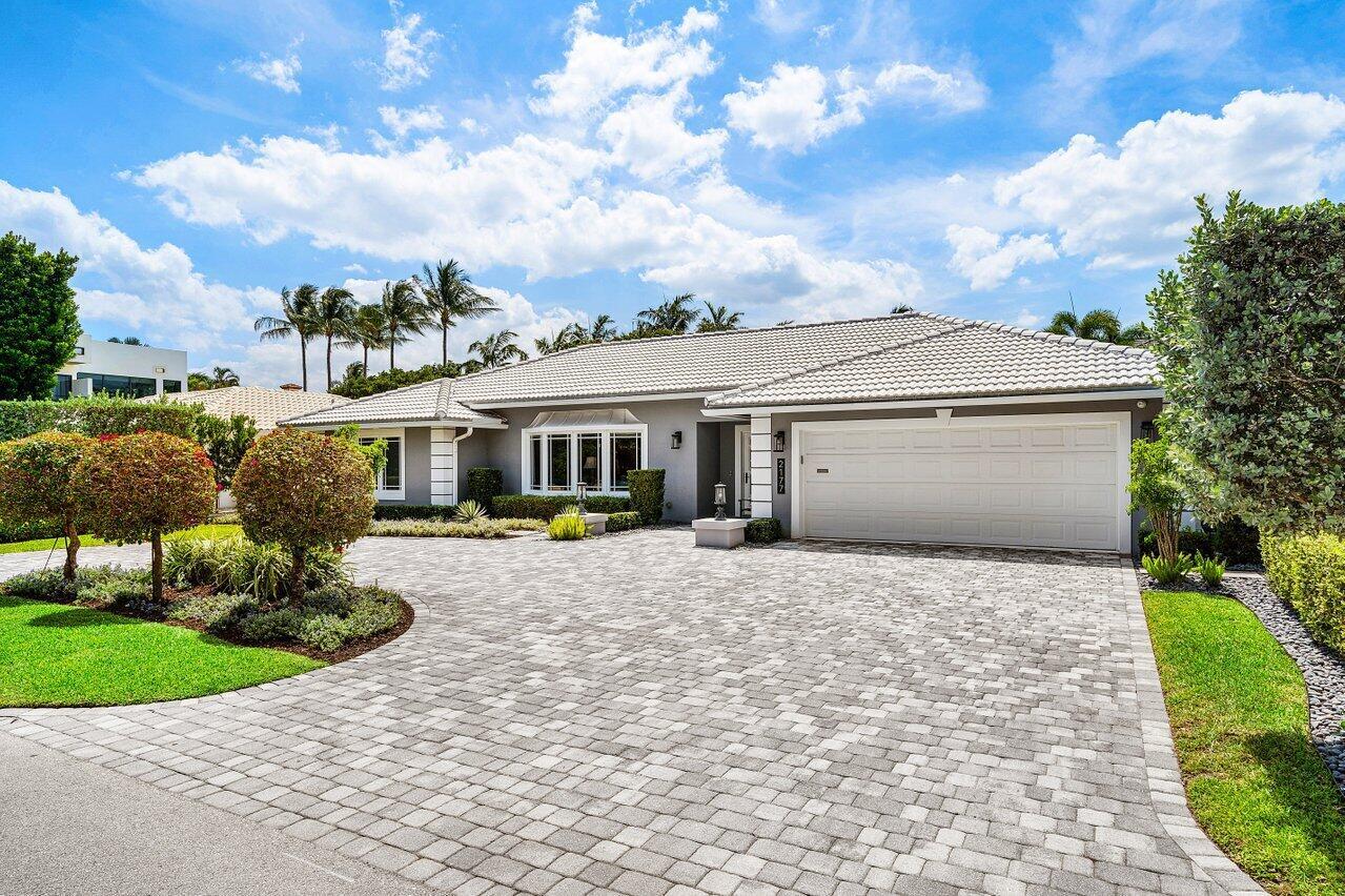 A single-story house with a gray exterior, tiled roof, and a large paved driveway — 2177 Areca Palm Road, Boca Raton FL 33432, BOCA RATON, FL